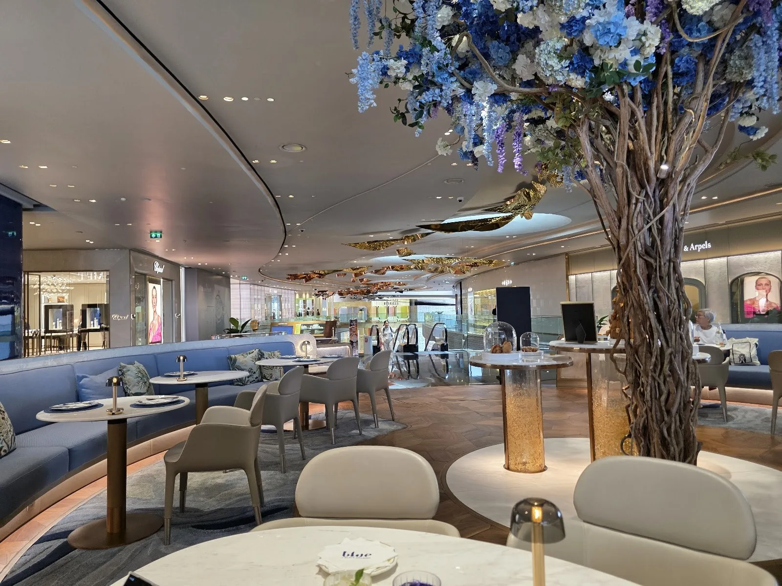 Blue by Alain Ducasse - add lounge reception with blue blossom tree centerpiece and cream lounge chairs