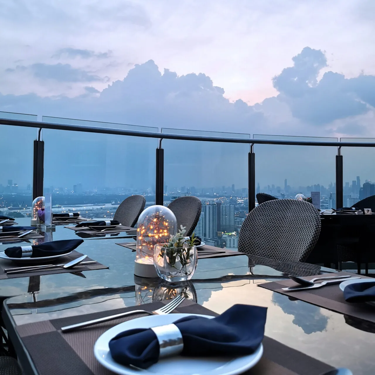 Cielo Sky Bar - rooftop dining table setting against the bangkok skyline