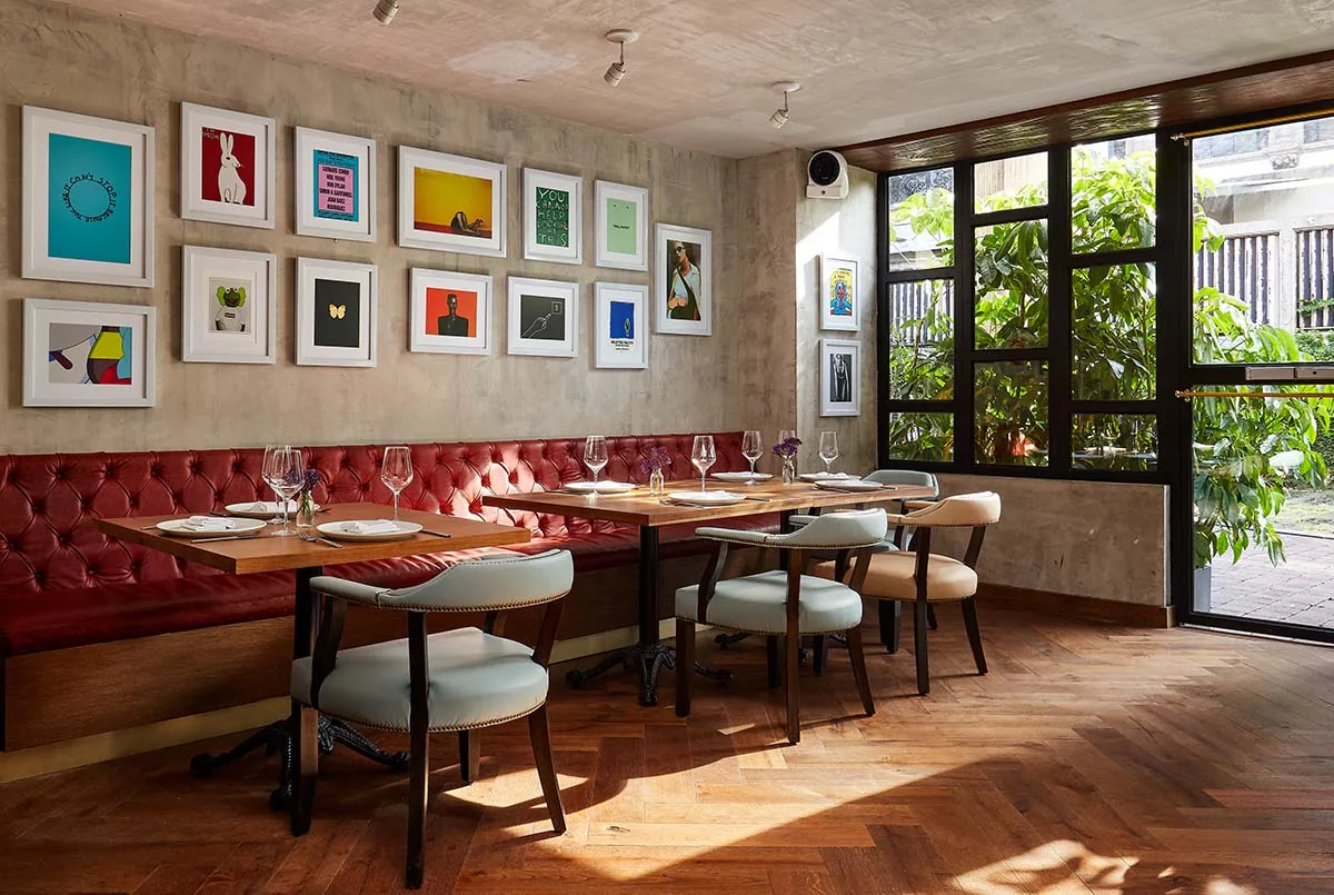 Dante Brasa y Fuego - banquette dining along the framed art wa