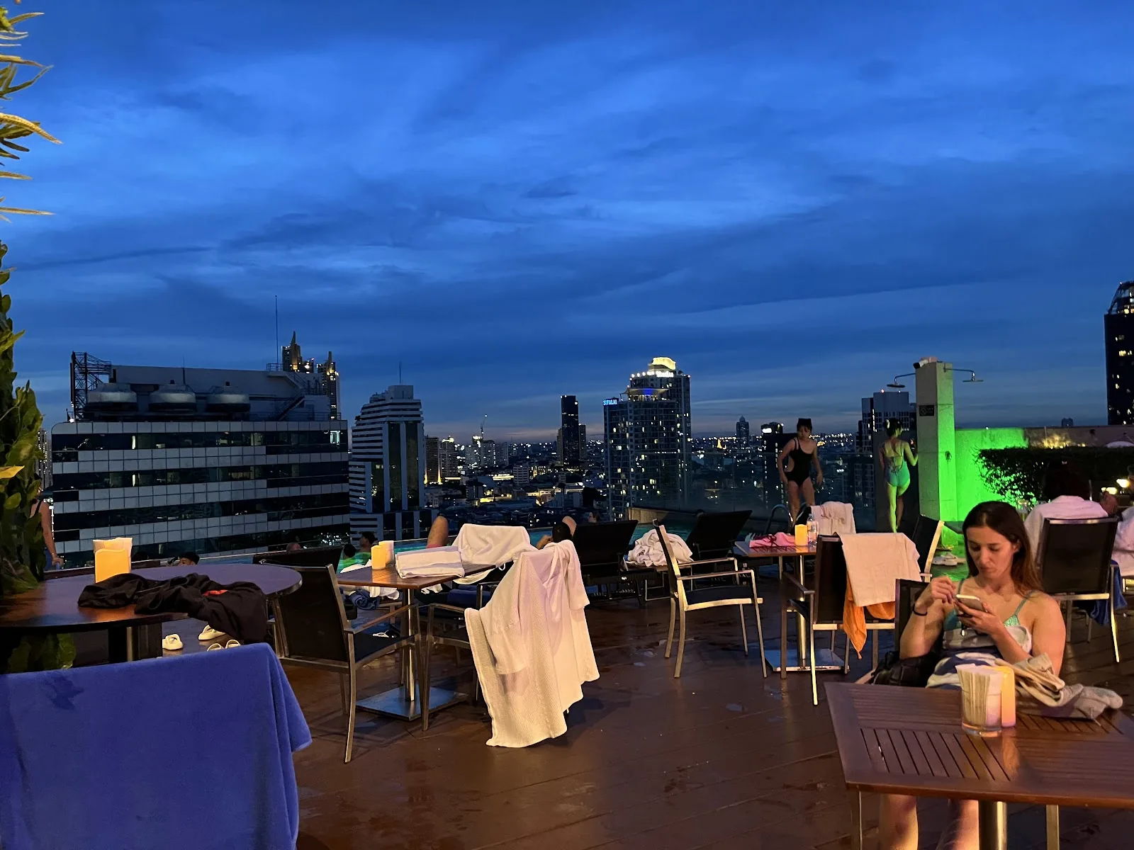 Hanuman Sky Bar / Akara Sky - rooftop open air terrace with tables at dusk over bangkok skyline