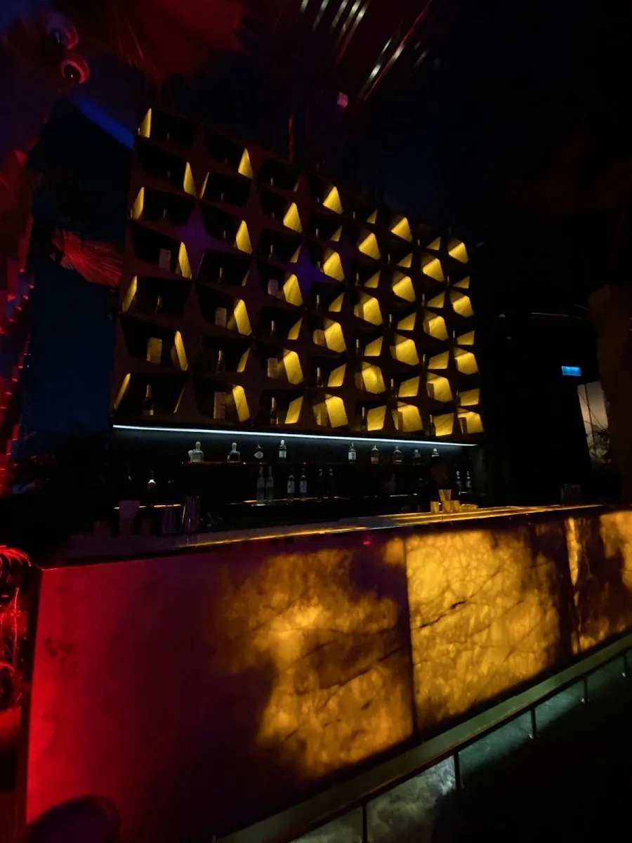 Levels Club & Lounge - fix gold quilted cube feature wall behind a backlit onyx bar counter moody clean architecture