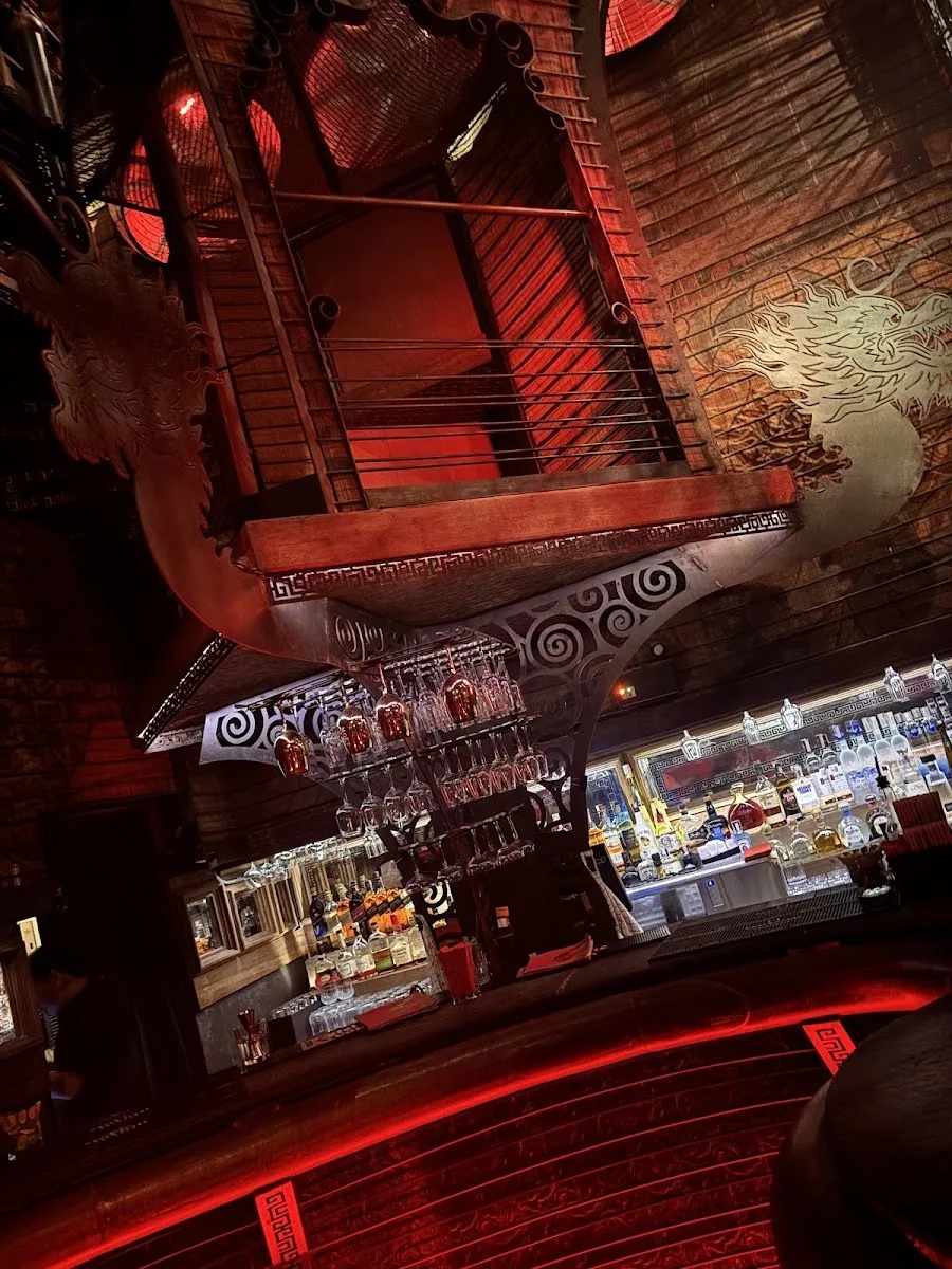 Sing Sing Theater - fix ornate carved bar crowned by a dragon boat sculpture red ambient distinctive bar feature