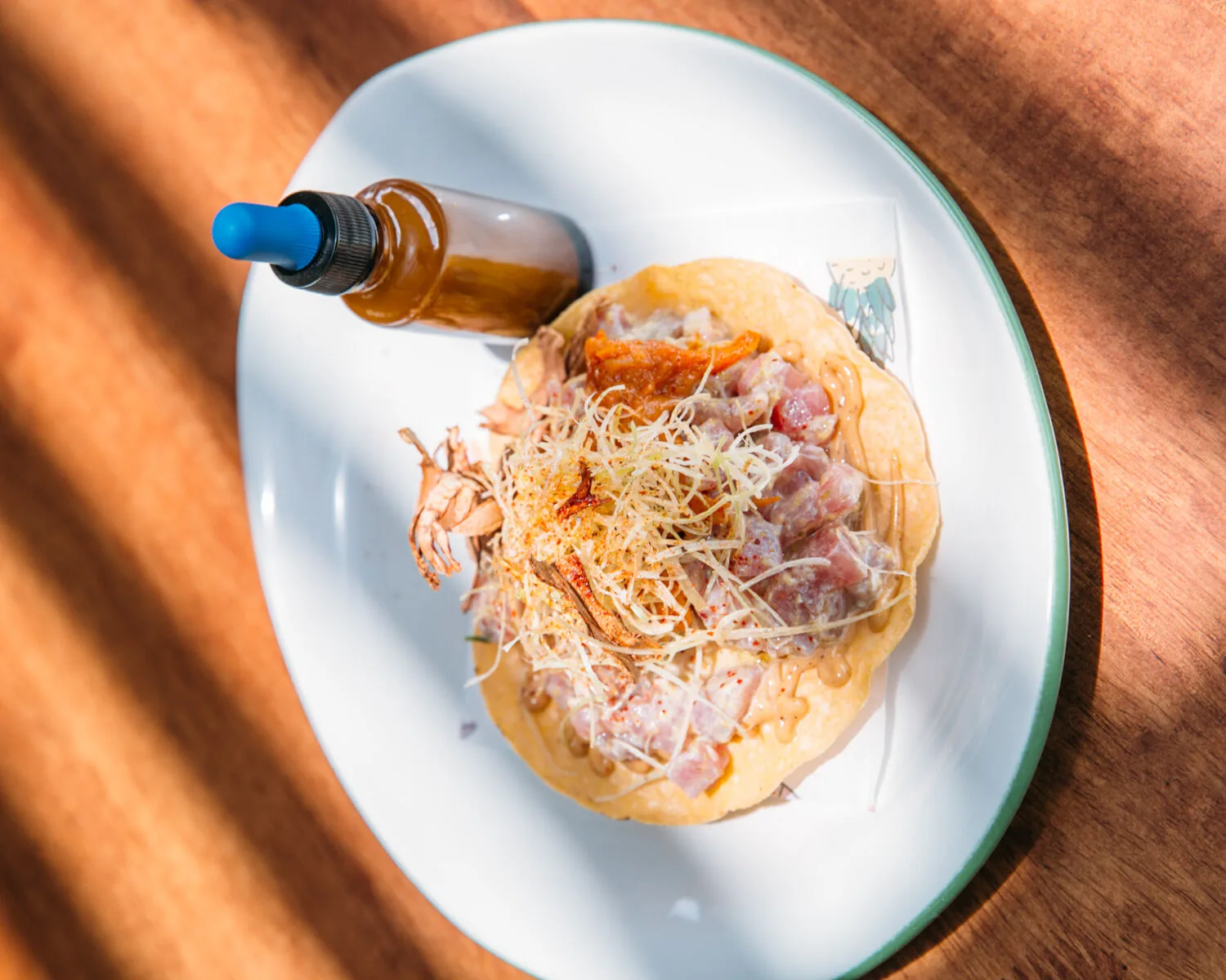 Terraza Cha Cha Cha - tostada plated with shredded topping and