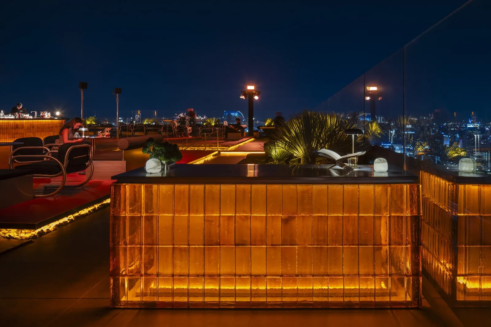 ÆTHER - fix aether signature glowing amber lit bar structure on the open rooftop deck at night