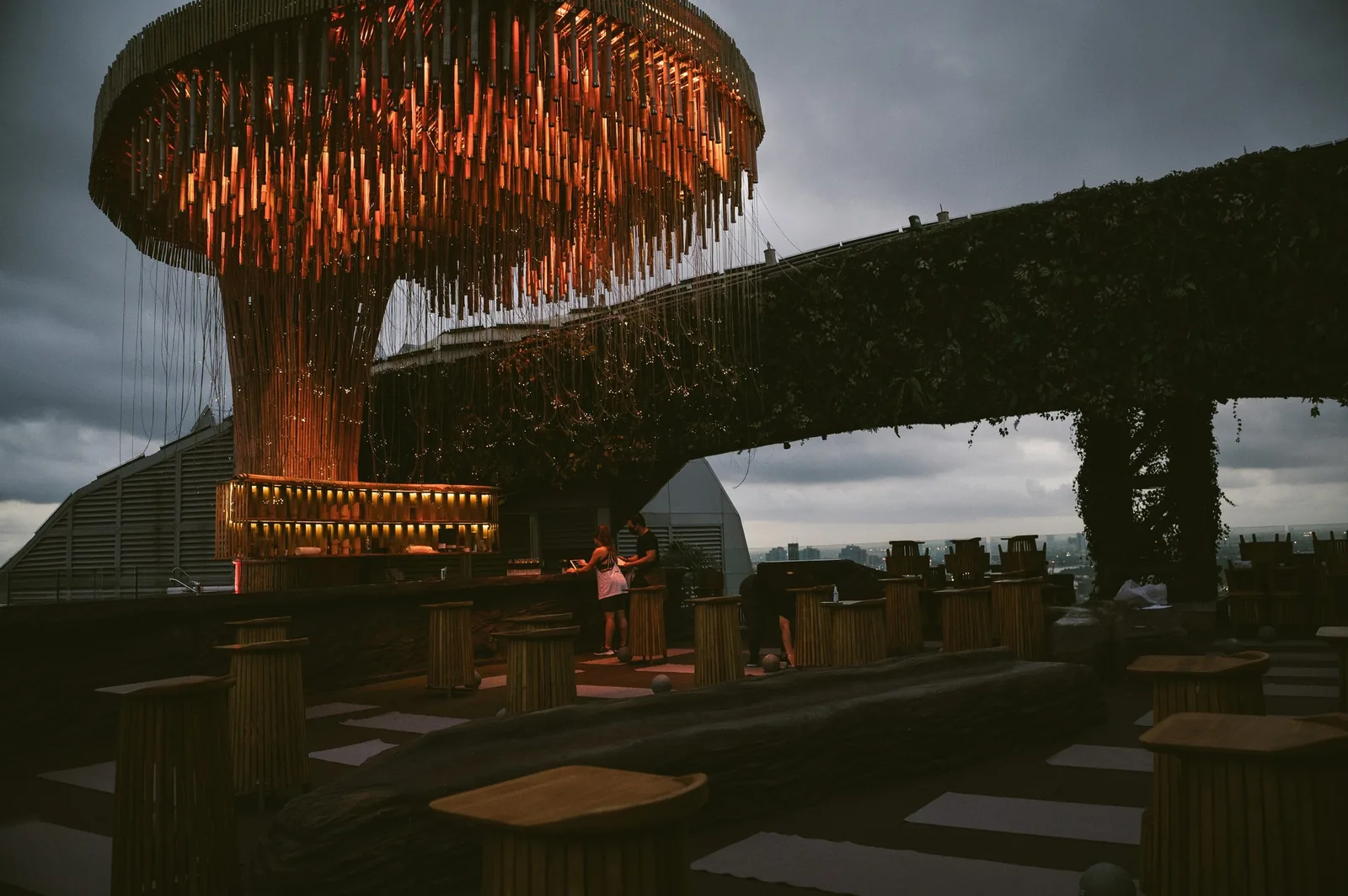 Tichuca Rooftop Bar - fix tichuca signature illuminated tree jellyfish canopy structure over the rooftop deck at dusk with seating and skyline