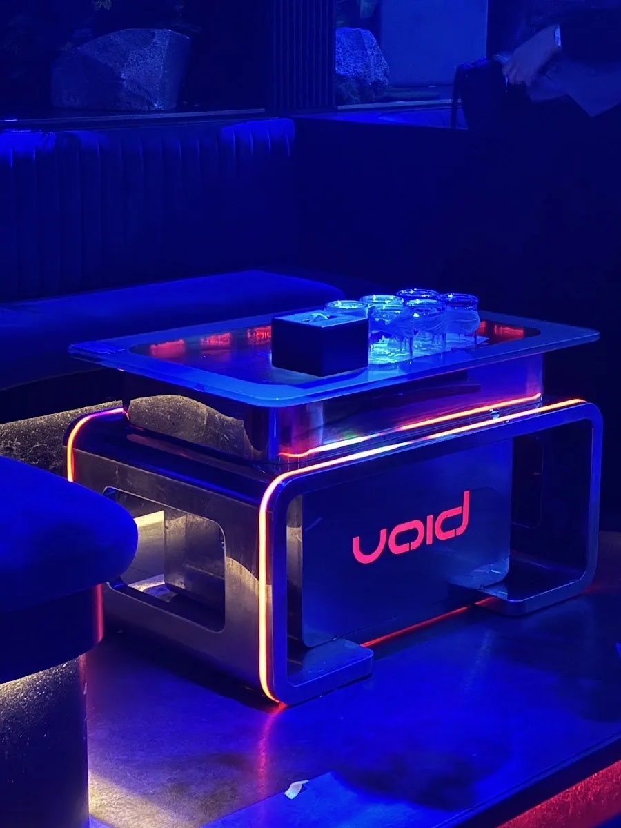 VOID Club - fix illuminated glass dj booth with red void led sign blue lit signature booth no crowd