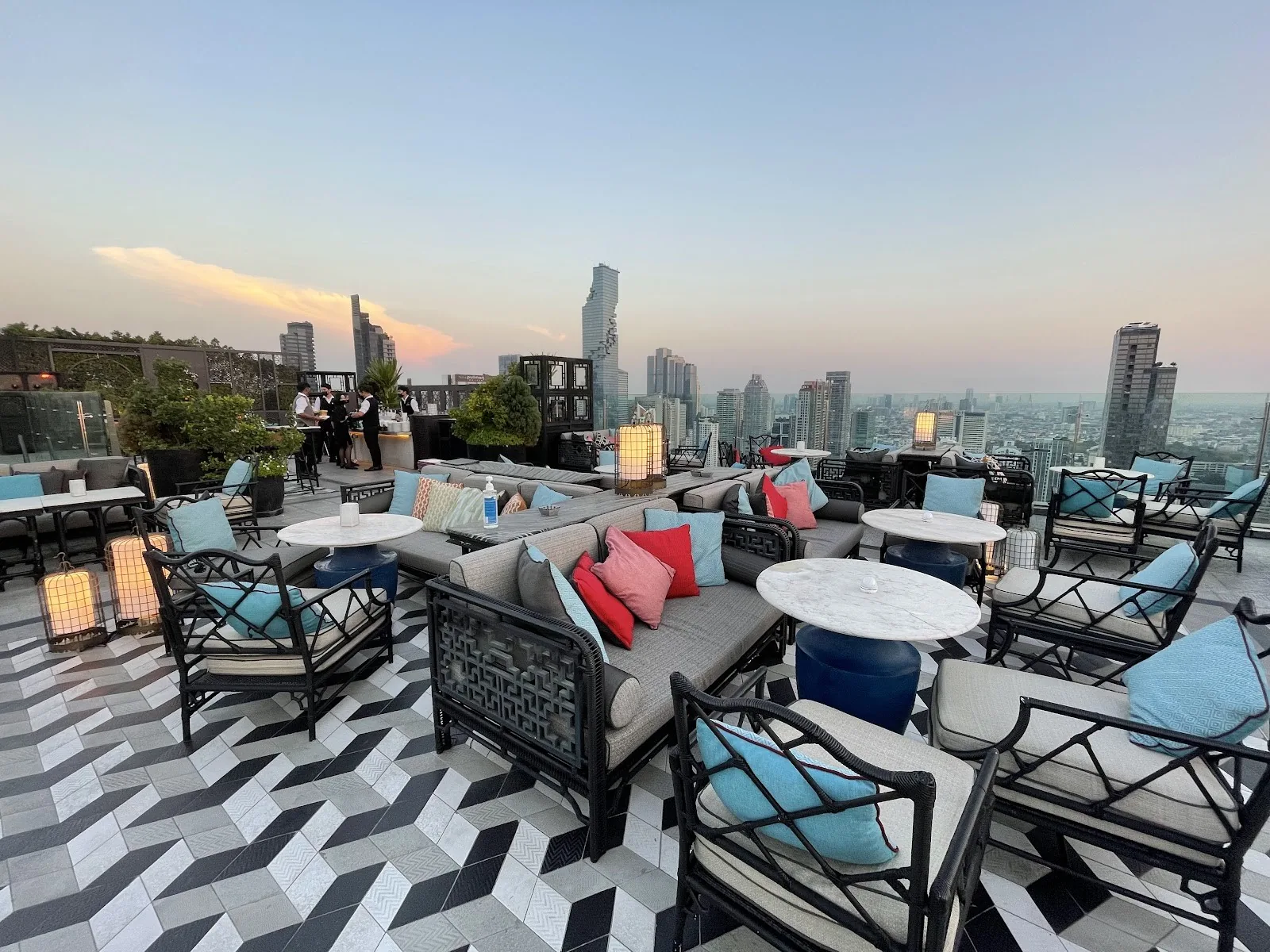 Yao Rooftop Bar - add rooftop lounge deck at dusk bold black white geometric floor colorful cushioned chairs skyline