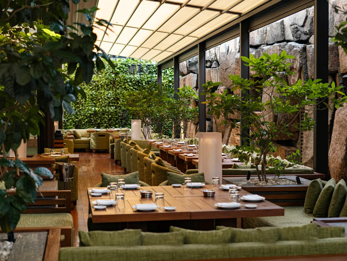 Zuma - signature garden terrace retractable glass roof tropical greenery informal dining non food covered dining terrace